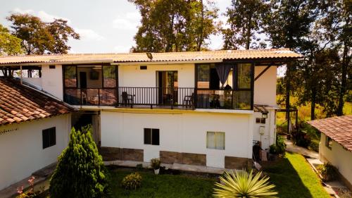 an exterior view of a house with a balcony at Hotel Campestre Nogal de Cafetal in Quimbaya