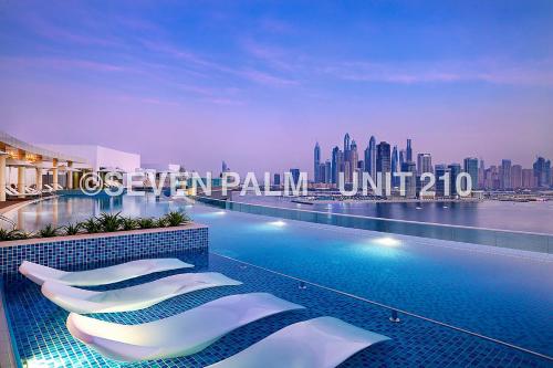 a hotel swimming pool with a view of a city at Luxus-Studio mit Private Beach in Top-Lage, Meerblick & Infinity Pool! in Dubai
