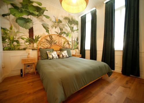 une chambre avec un lit avec une couette verte dans l'établissement L'arbre d'or Appart hyper centre spa couvert, à Cambrai