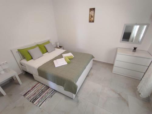 a bedroom with a large bed with green pillows at Apartment with Terrace and Garden in Pirovac