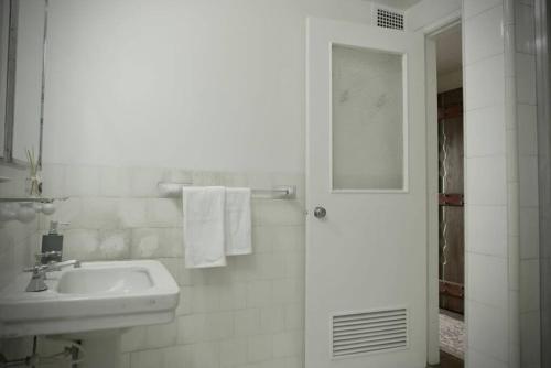a white bathroom with a sink and a mirror at Apartamento completo centro de Bogotá in Bogotá