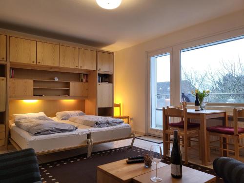 1 dormitorio con 1 cama y comedor con mesa en Haus zur Dünenbake - Apartment 24, en Sankt Peter-Ording
