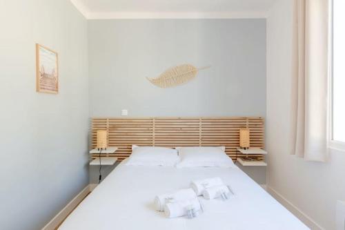 a bedroom with a white bed with two white pillows at Charmante maison à 100M de la plage in Pornic