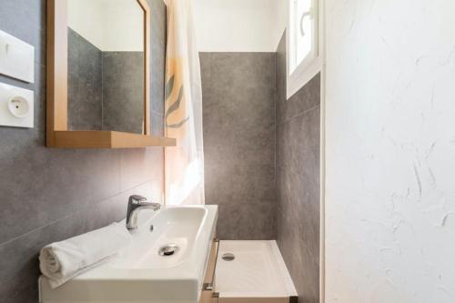 a bathroom with a sink and a mirror at Charmante maison à 100M de la plage in Pornic