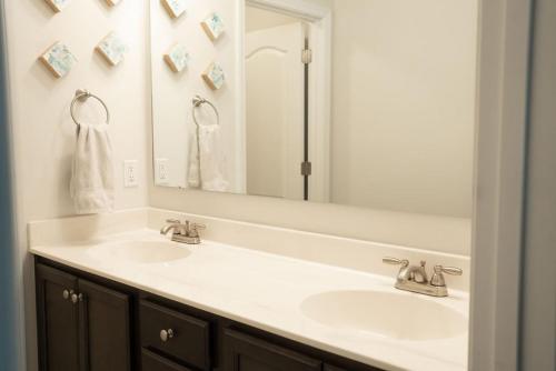 łazienka z 2 umywalkami i dużym lustrem w obiekcie Sleeps 9- In Whispering Pines w mieście Carthage