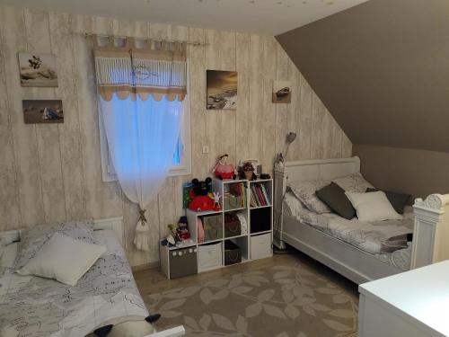 - une petite chambre avec 2 lits et une fenêtre dans l'établissement OMAHA-BEACH maison cosy, à Saint-Laurent-sur-Mer