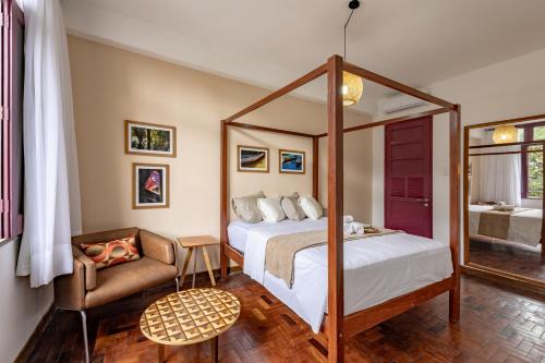 a bedroom with a canopy bed and a chair at Hotel Casa do Bispo in Manaus