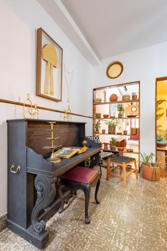 a living room with a piano and a table at Hotel Casa do Bispo in Manaus