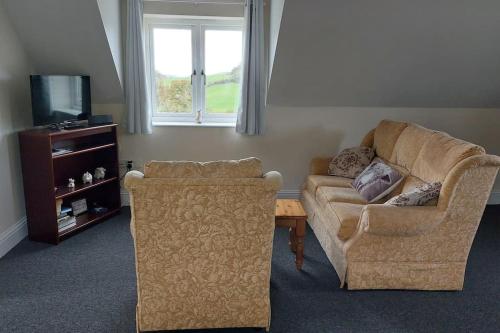 a living room with a couch and a table at Farm Loft in Shepton Mallet