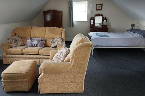 a living room with a couch and a bed at Farm Loft in Shepton Mallet