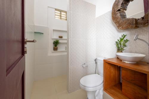 a bathroom with a toilet and a sink and a shower at Hotel Casa do Bispo in Manaus