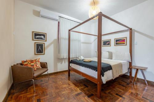 a bedroom with a canopy bed and a chair at Hotel Casa do Bispo in Manaus