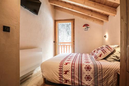 een slaapkamer met een bed en een raam bij Alpen Chalet in Morzine