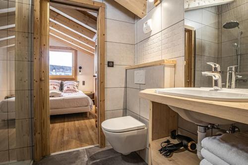een badkamer met een toilet, een wastafel en een bed bij Alpen Chalet in Morzine