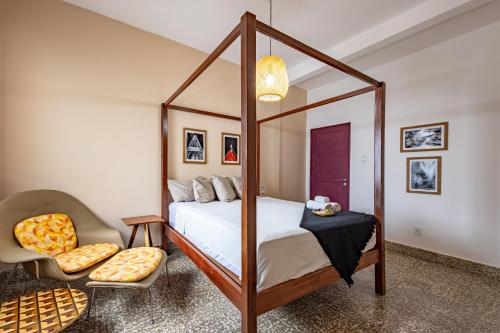 a bedroom with a canopy bed and a chair at Hotel Casa do Bispo in Manaus
