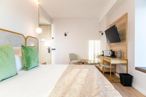 a bedroom with a bed and a desk with a computer at Hotel Málaga Vibes in Málaga