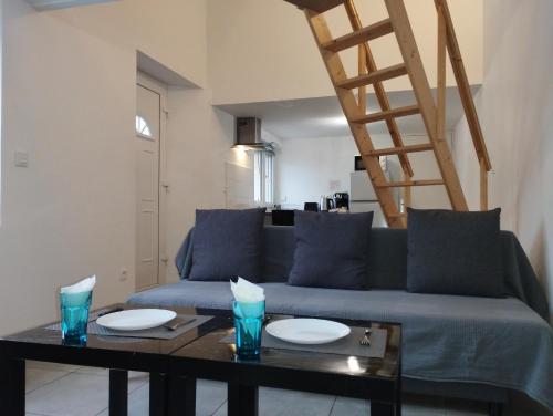 sala de estar con sofá azul y mesa en Appartement 1, jardin, collation, 5 min de l'aéroport CDG, en Le Mesnil-Amelot