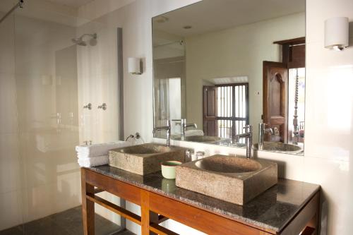 a bathroom with two sinks and a large mirror at Saratha Vilas Chettinad in Kānādukāttān