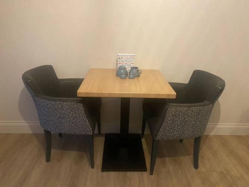 a table with two chairs and a table with shoes on it at Castletroy Apartment in Limerick