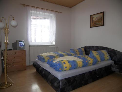 a bedroom with a bed with blue and yellow pillows at Penzion U Antonickova Pramene in Mariánské Lázně