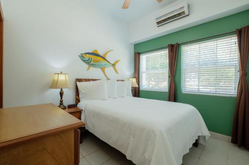 a bedroom with a bed with a fish on the wall at Best Western Grand Baymen Gardens in San Pedro