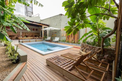 a swimming pool on a wooden deck with two chairs at Hotel Casa do Bispo in Manaus