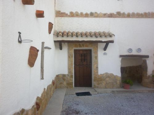 a building with a door and a stone wall at Alojamiento Rural LA TEJA in Cortes de Baza