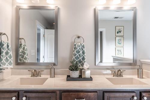 a bathroom with two sinks and two mirrors at Sleeps 8- In Whispering Pines 