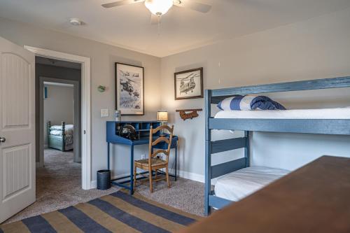 a bedroom with two bunk beds and a desk at Sleeps 8- In Whispering Pines 