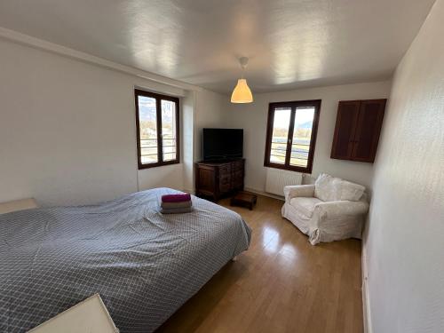 1 dormitorio con 1 cama y 1 silla en Logements Gare Brignoud, en Villard-Bonnot