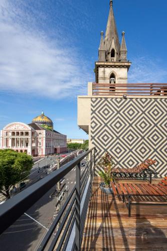 a balcony with a bench and a clock tower at Hotel Casa do Bispo in Manaus