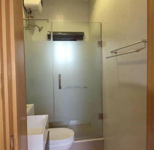 a bathroom with a glass shower with a toilet and a sink at Supreme Apartments in Ibadan