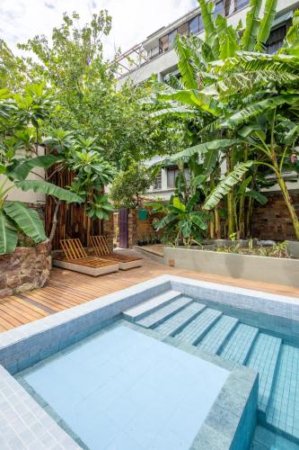 a swimming pool in a garden with trees and a building at Hotel Casa do Bispo in Manaus
