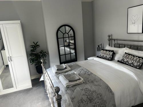 a bedroom with a large bed and a mirror at Quay Cottage in Parkgate