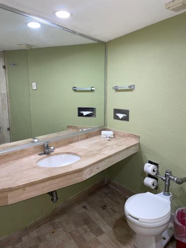 a bathroom with a sink and a toilet and a mirror at Hotel Arroyo de la Plata in Zacatecas
