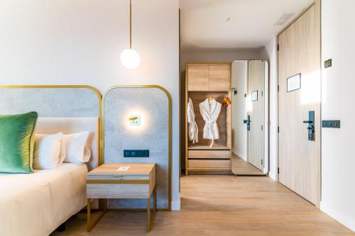 a bedroom with a bed and a dressing room at Hotel Málaga Vibes in Málaga