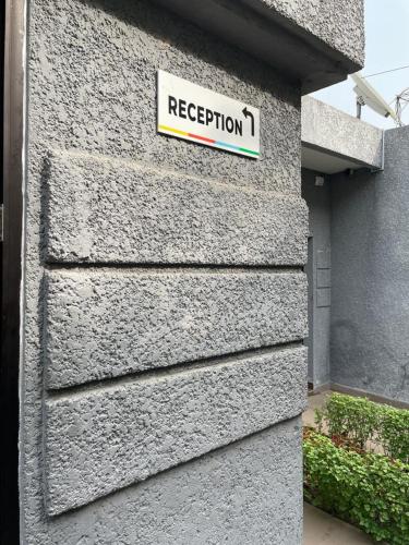 a sign on the side of a building with a rejection sign at Hôtel Guest House Quatre Saisons in Cadjèhoun