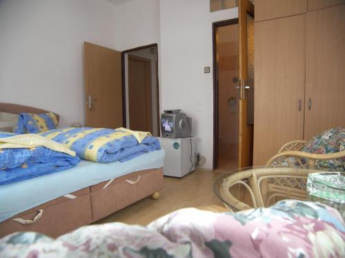a bedroom with two beds and a television in it at Penzion U Antonickova Pramene in Mariánské Lázně