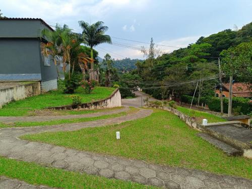 a winding road leading to a house on a hill at Pousada Styllus Miguel Pereira in Miguel Pereira