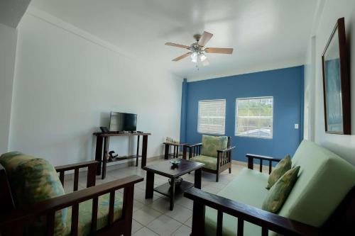 a living room with a couch and a ceiling fan at Best Western Grand Baymen Gardens in San Pedro