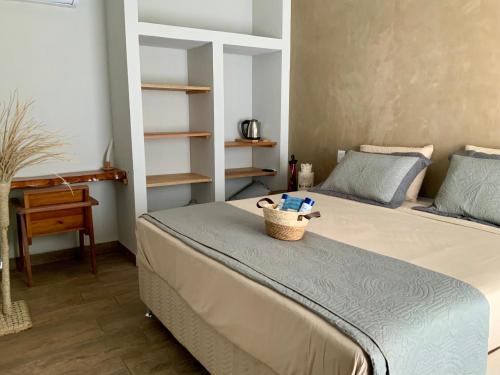 a bedroom with a bed with a basket on top of it at La Maison Loosaï -Σlégance-avec TV in Itacaré