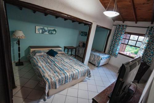 1 dormitorio con 1 cama, 1 silla y 1 ventana en Alameda Galu en Atibaia