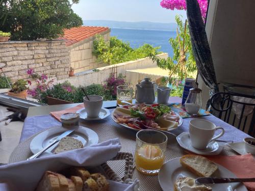 uma mesa com comida e vista para o oceano em Rooms Pere s mora em Mimice
