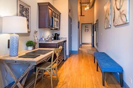 a kitchen with a table and a blue bench at Hip Urban Loft - Small Town Charm - 124 LOFTS #1 in West Dundee