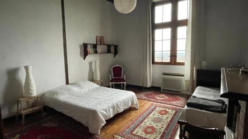 une chambre avec un lit blanc et une fenêtre dans l'établissement LE POUY, à Saint-Martin-de-Hinx