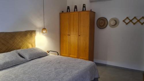 1 dormitorio con 1 cama y armario de madera en SUÍTE EM PIPA COM CAFÉ DA MANHÃ, en Tibau do Sul