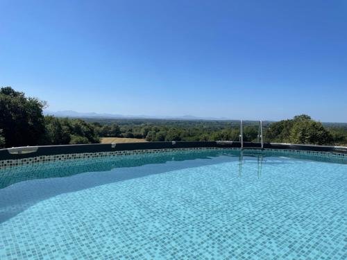 une grande piscine avec vue sur la campagne dans l'établissement LE POUY, à Saint-Martin-de-Hinx