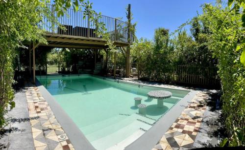 una piscina con un puente y una mesa. en Hotel Vendimia Parador, en Santa Cruz