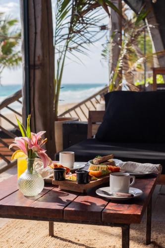 a table with a tray of food and coffee cups at Casa Gitano in Tulum