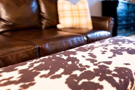 a brown leather couch and a leather chair in a living room at Hip Urban Loft-Small Town Charm-124 LOFTS #2 in West Dundee